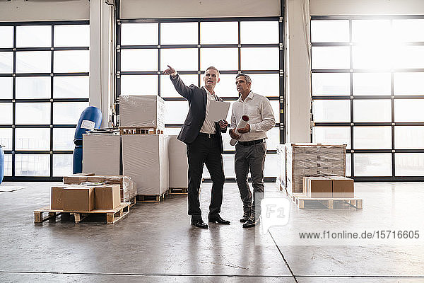 Zwei Geschäftsleute im Gespräch in einer Fabrik