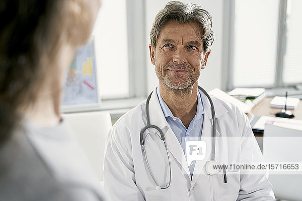 Arzt mit Patientin in seiner Praxis