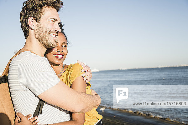 Glückliches junges Paar umarmt sich an der Uferpromenade  Lissabon  Portugal