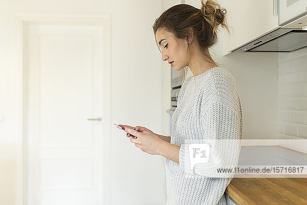 Junge Frau benutzt Smartphone zu Hause