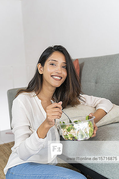 Porträt einer entspannten jungen Geschäftsfrau mit Schüssel mit gemischtem Salat