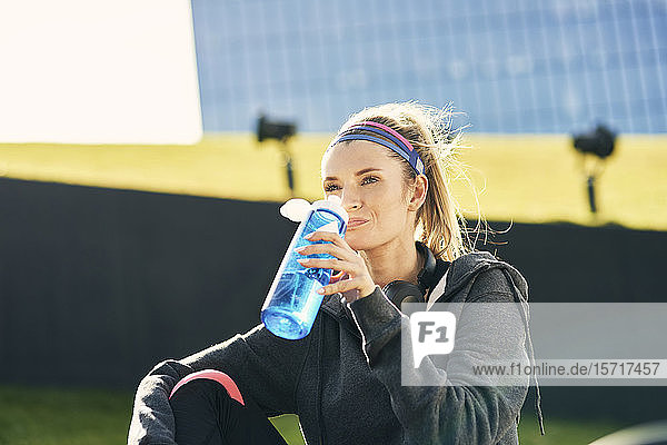 Frau trinkt Wasser nach hartem Training
