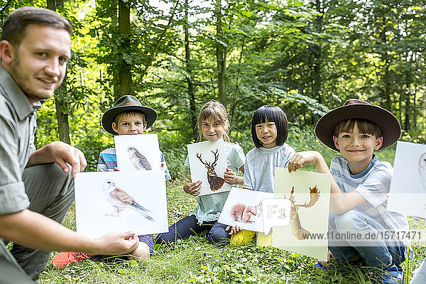 School children doung nature studies  holding pictures of animals