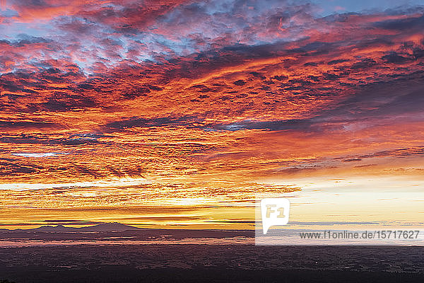 Neuseeland  Dramatischer Sonnenaufgang über dem Tongariro-Nationalpark mit den Silhouetten von Vulkanen in der Ferne