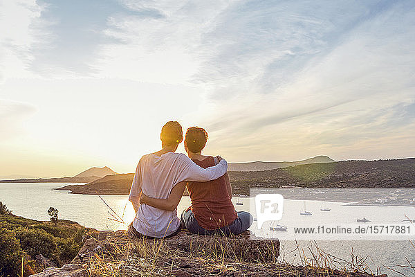 Ein Paar beobachtet den Sonnenuntergang am Kap Sounion  Attika  Griechenland