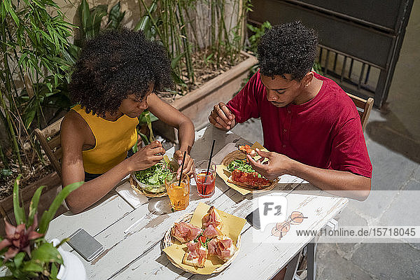 Young couple having a drink and amtipasti at an outdoor bar