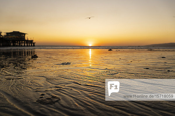 USA  Kalifornien  Santa Monica  Nasser Sand des Küstenstrandes bei Sonnenuntergang mit dem Santa Monica Pier im Hintergrund