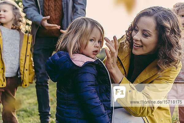 Glückliche Mutter mit Tochter und Familie im Herbst im Freien