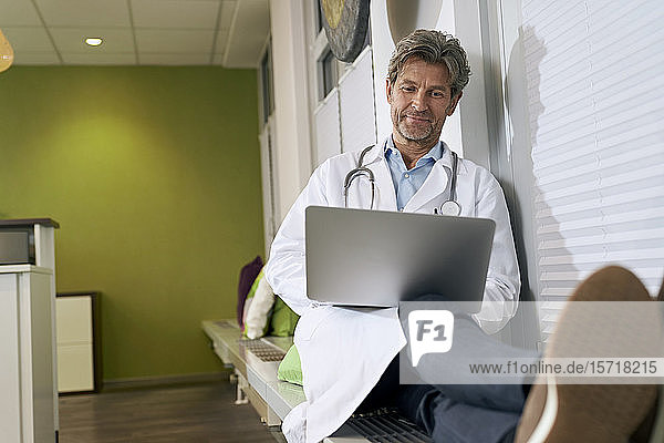Arzt benutzt Laptop in seiner Praxis