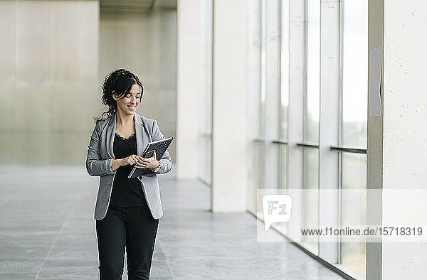 Smiling businesswoman using tablet at the window