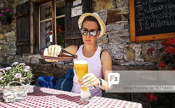 Frau schenkt auf einer Berghütte ein Weissbier ein  Passeiertal  Südtirol  Italien