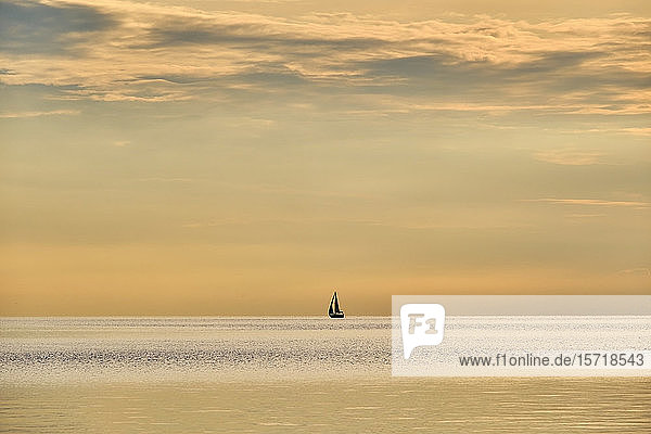 Italien  Trentino  Nago-Torbole  Silhouette eines Segelboots  das im launischen Morgengrauen über den Gardasee fährt