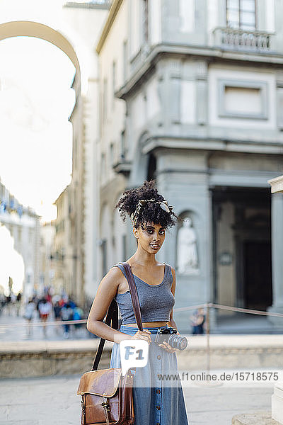 Porträt einer jungen Frau mit Kamera  die die Stadt erkundet  Florenz  Italien