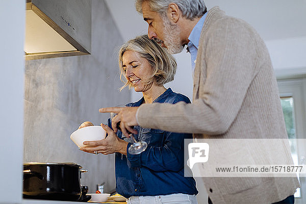 Reifere Paare bereiten das Abendessen zu Hause in der Küche zu