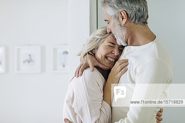 Affectionate mature couple hugging at home