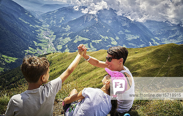 Glückliche Mutter mit zwei Kindern bei einer Wanderpause in alpiner Landschaft  Passeiertal  Südtirol  Italien
