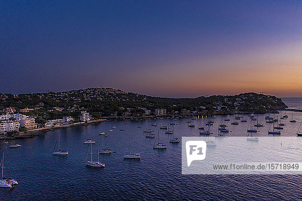 Spanien, Mallorca, Santa Ponsa, Luftaufnahme von Booten, die in der Abenddämmerung im Küstengewässer treiben