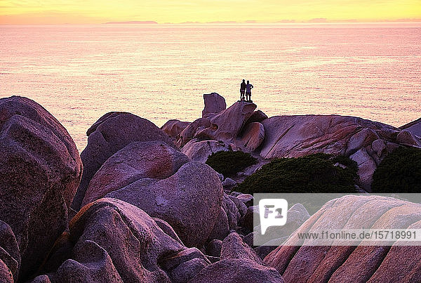 Italien  Provinz Sassari  Santa Teresa Gallura  Silhouette eines Paares  das den Sonnenuntergang über dem Mittelmeer von der Spitze des Kap Testa bewundert