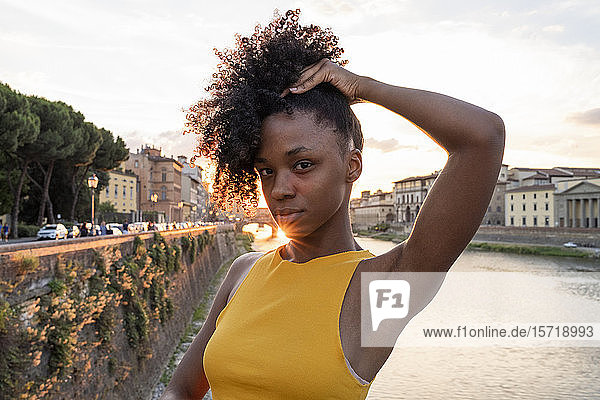 Porträt einer selbstbewussten jungen Frau am Fluss Arno bei Sonnenuntergang  Florenz  Italien