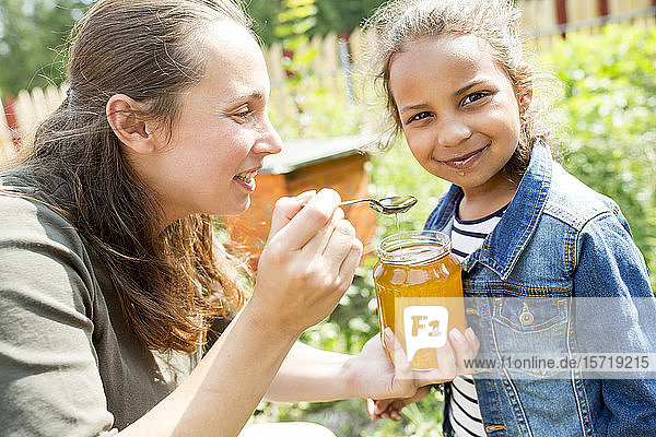 Kleines Mädchen schmeckt natürlichen Honig