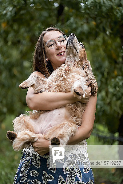 Woman holding her dog outdoors