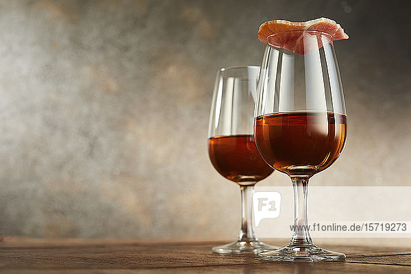 Studioaufnahme von zwei Gläsern traditionellem spanischen Sherry  mit Schinken bedeckt