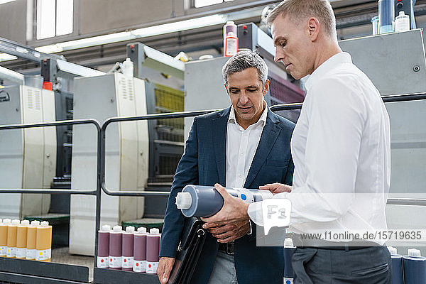 Two businessmen examining product in a factory