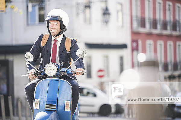 Junger Geschäftsmann fährt Motorroller in der Stadt Lissabon Portugal