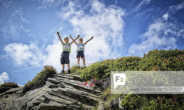 Junge und Mädchen stehen auf Berggipfel und jubeln  Passeiertal  Südtirol  Italien