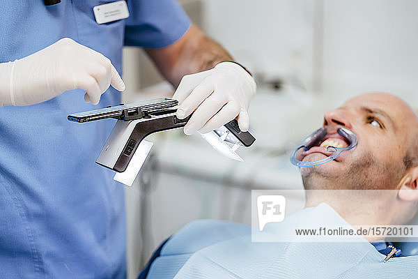 Nahaufnahme eines Zahnarztes  der Zahnersatz mit einem speziellen Fotoapparat fotografiert