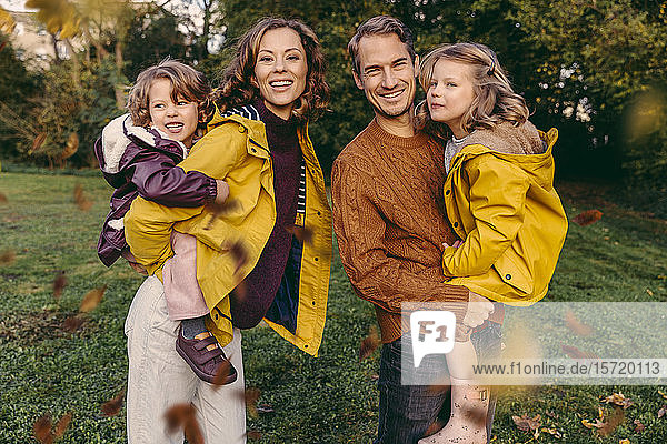 Porträt einer glücklichen Familie mit zwei Töchtern im Herbst im Freien