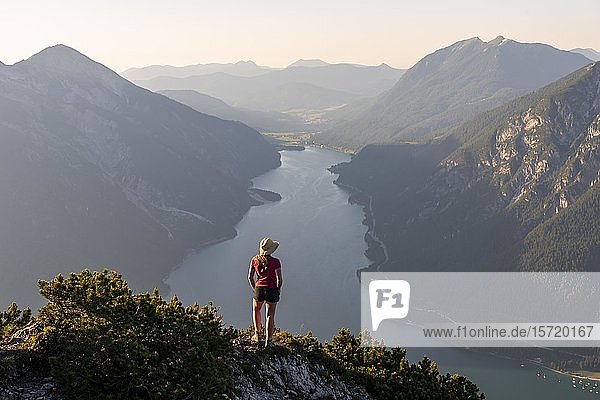 Young woman looking over mountain landscape  view from the mountain Bärenkopf to Lake Achensee  left Seebergspitze and Seekarspitze  right Rofan Mountains  Tyrol  Austria  Europe