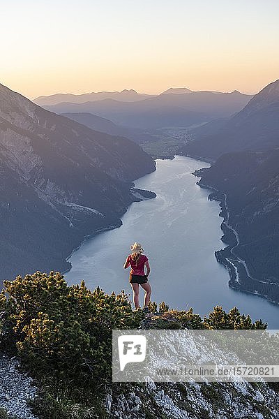 Sunset  young woman looking over mountain landscape  view from the mountain Bärenkopf to Lake Achensee  Tyrol  Austria  Europe