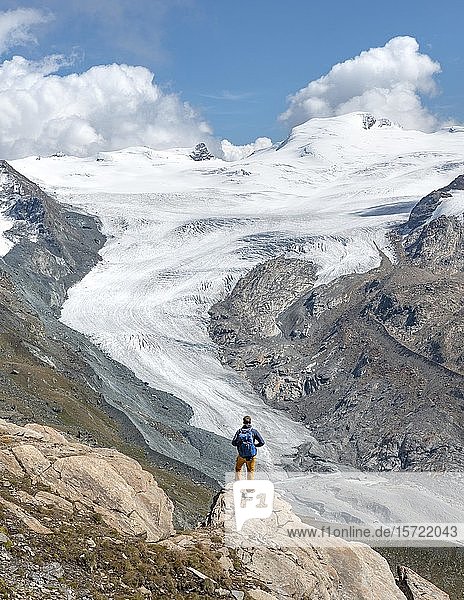Hiker looks from the mountain Unterrothorn onto the glacier tongue of the Findel Glacier  Zermatt  Walliss  Switzerland  Europe