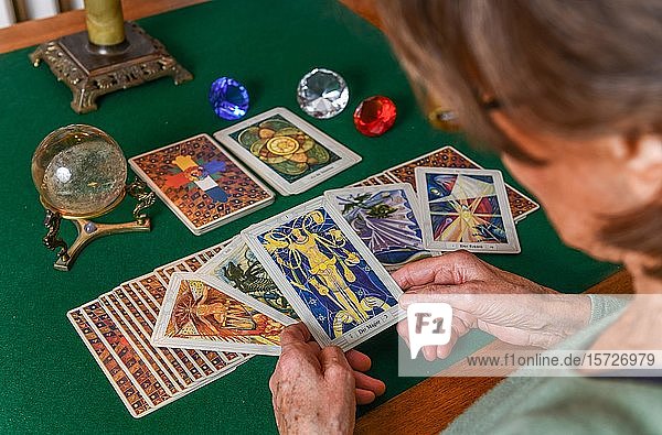 Tarotkarten  Frau liest Zukunft aus den Karten  Karten und Glaskugel auf einem Tisch  Deutschland  Europa