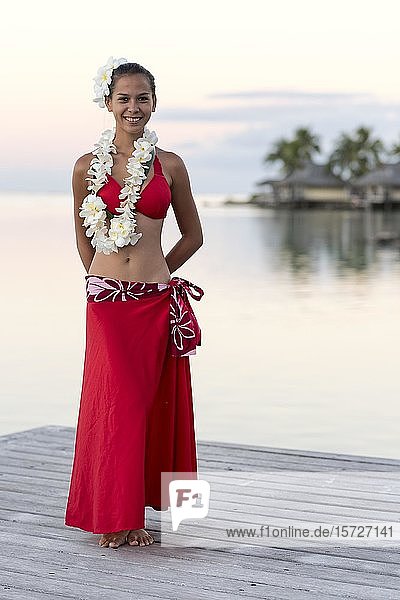 Einheimische junge Frau mit Blumenschmuck steht auf einem Steg am Wasser  Moorea  Französisch-Polynesien  Ozeanien