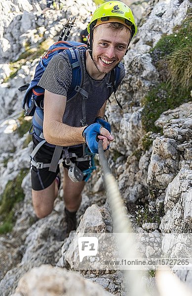 Mountaineer  young man with helmet on a secured fixed rope route  Mittenwald via ferrata  Karwendel Mountains  Mittenwald  Germany  Europe