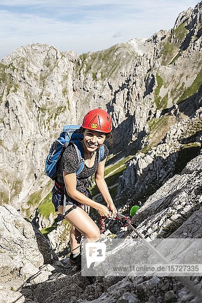 Bergsteigerin  junge Frau mit Helm auf einem gesicherten Klettersteig  Mittenwalder Klettersteig  Karwendelgebirge  Mittenwald  Deutschland  Europa