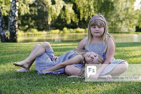 Zwei Mädchen  Geschwister auf der Wiese sitzend  6 und 7 Jahre  Porträt  Tschechische Republik  Europa