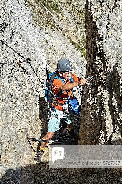 Bergsteiger  Mann mit Kletterhelm an einem gesicherten Klettersteig  Mittenwalder Klettersteig  Karwendelgebirge  Mittenwald  Deutschland  Europa