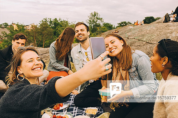 Lächelnde Frau beim Picknick mit Freunden