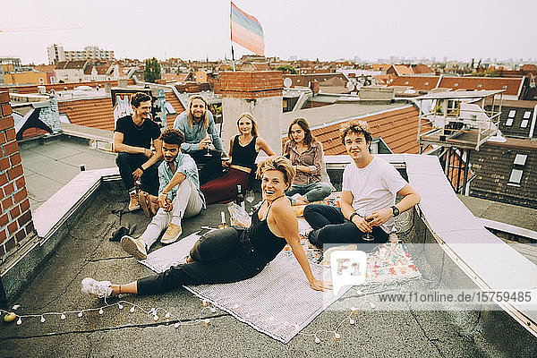 Hochwinkelporträt von Freunden  die sich während einer Party auf einer Terrasse in der Stadt entspannen
