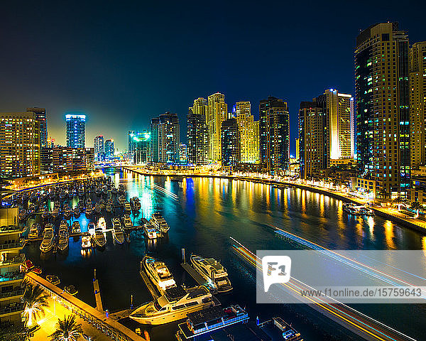 Nachtszene mit Stadtsilhouette und im Hafen vertäuten Booten  Dubai