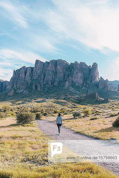 Woman walking  Superstition mountains in background  Arizona  United States