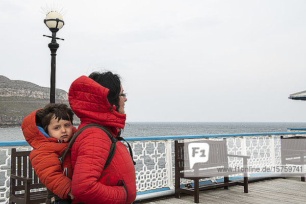 Mutter und Sohn auf einem Pier an der Küste