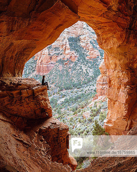 Frau sitzt auf einer Felskante in einer Höhle  Sedona  Arizona  Vereinigte Staaten