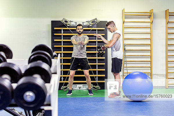 Mann trainiert Freund im Fitnessstudio