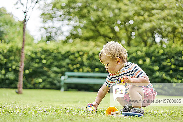 Kleinkind spielt mit Spielzeugauto auf dem Parkplatz