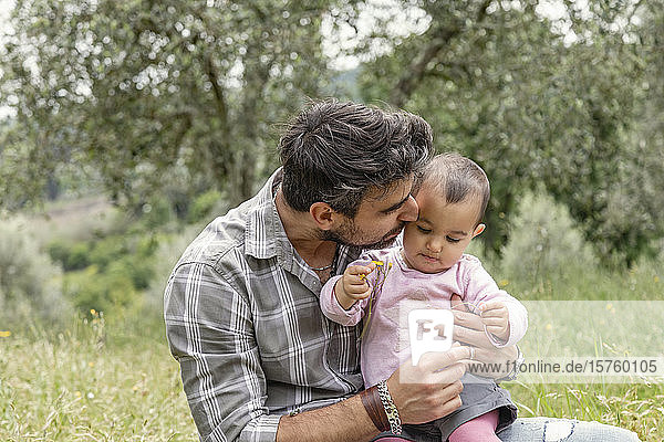 Vater küsst kleines Mädchen im Garten  Florenz  Italien
