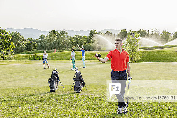 Mann geht mit sich selbst auf den Golfplatz  Freunde spielen Golf im Hintergrund